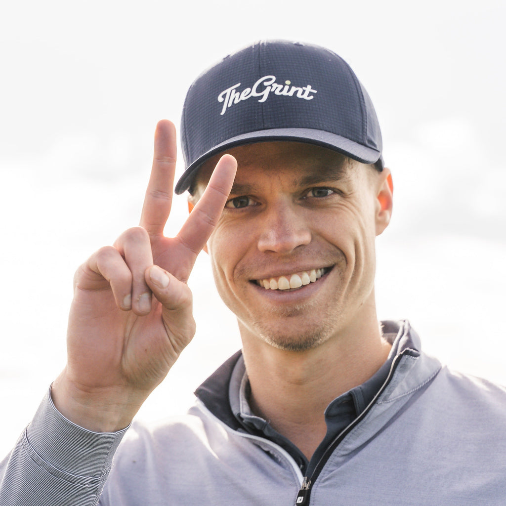 Golfer wearing a TheGrint script logo snapback